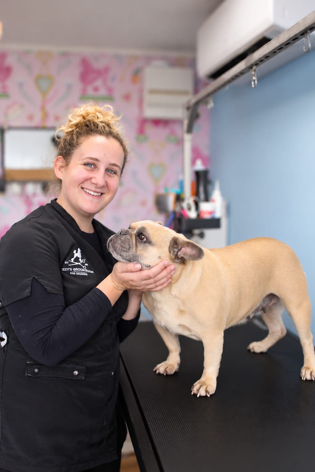 The founder in her grooming salon with a French bulldog